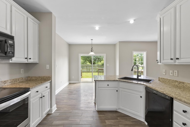 kitchen featuring decorative light fixtures, black appliances, sink, white cabinets, and light stone counters