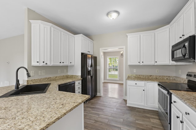 kitchen with light stone countertops, black appliances, white cabinetry, an inviting chandelier, and sink