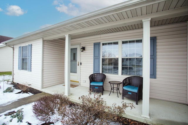 snow covered patio featuring a porch