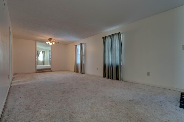 carpeted spare room featuring ceiling fan and a textured ceiling