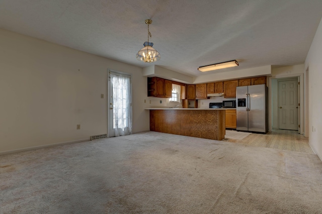 kitchen featuring an inviting chandelier, kitchen peninsula, stainless steel fridge, light colored carpet, and pendant lighting