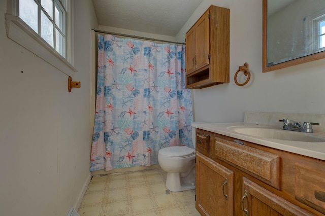 bathroom featuring toilet, vanity, walk in shower, and a healthy amount of sunlight