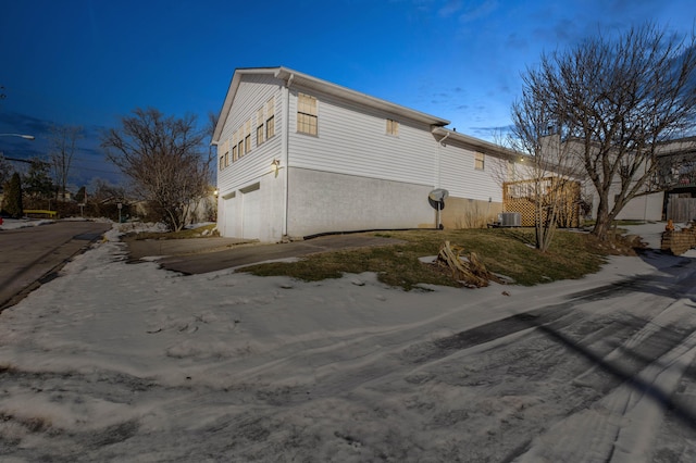 view of side of home featuring a garage and central air condition unit