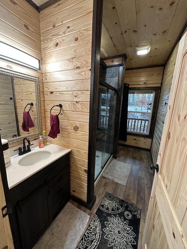 bathroom with wood-type flooring, wooden ceiling, wooden walls, and vanity