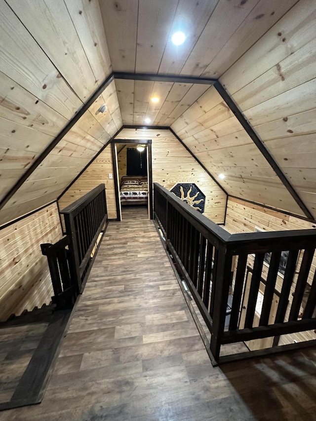 hall with wood ceiling, wooden walls, and vaulted ceiling