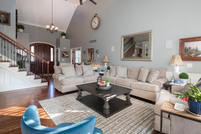 living room with ornamental molding, a chandelier, dark hardwood / wood-style floors, and high vaulted ceiling