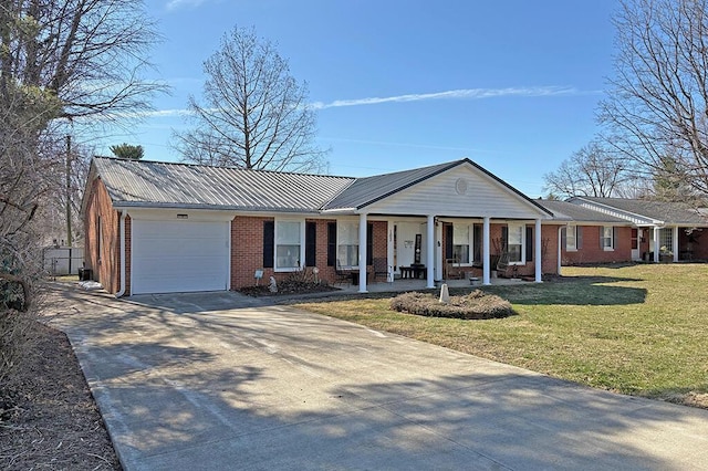 ranch-style house featuring concrete driveway, metal roof, an attached garage, a front lawn, and brick siding