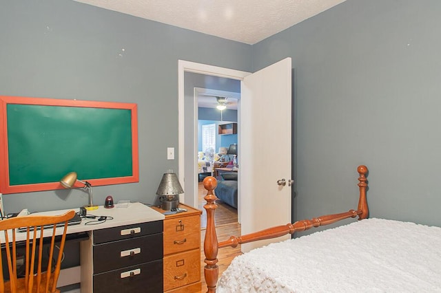 bedroom with a textured ceiling and wood finished floors