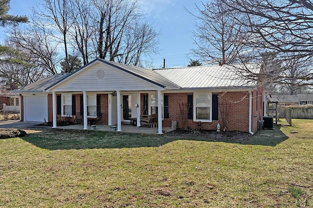 view of front of property with brick siding, central air condition unit, covered porch, an attached garage, and a front yard