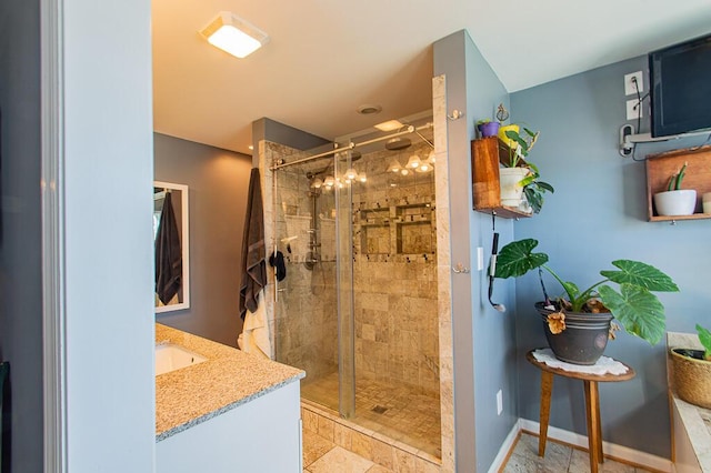 bathroom with a shower stall, vanity, and baseboards