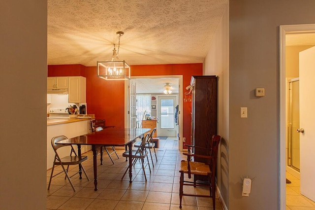 dining space with a chandelier, light tile patterned floors, and a textured ceiling