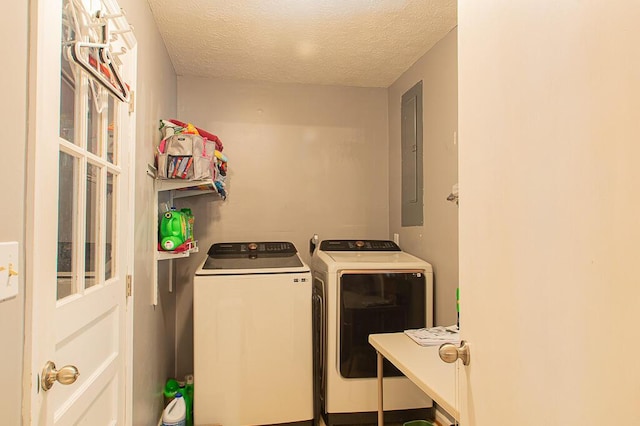 laundry room with electric panel, independent washer and dryer, and a textured ceiling