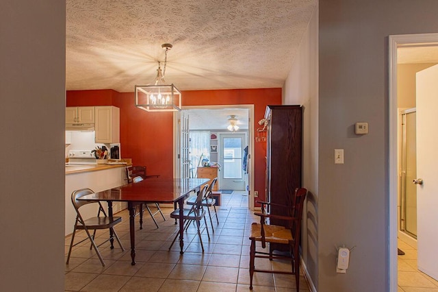 dining area featuring a notable chandelier, a textured ceiling, and light tile patterned flooring