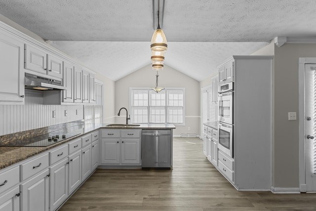 kitchen featuring pendant lighting, kitchen peninsula, sink, stainless steel appliances, and white cabinets