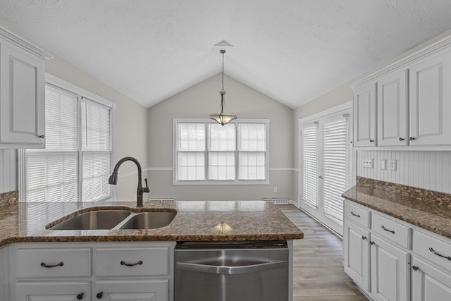 kitchen with white cabinetry, hardwood / wood-style flooring, dishwasher, vaulted ceiling, and sink