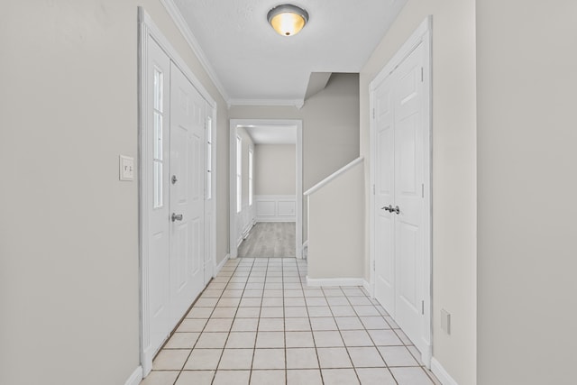 hall with light tile patterned floors and crown molding