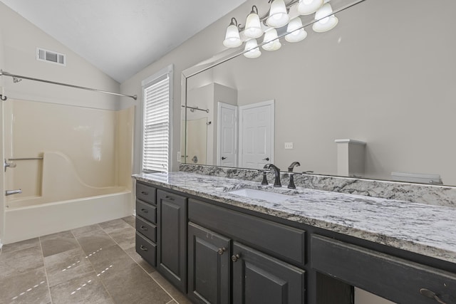 bathroom featuring vanity, vaulted ceiling, and shower / bath combination