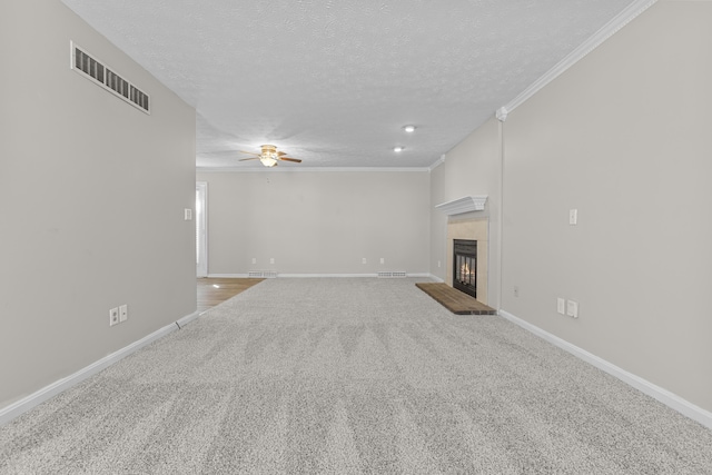 unfurnished living room with ceiling fan, ornamental molding, a textured ceiling, and carpet flooring