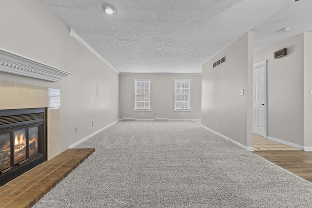 carpeted living room featuring ornamental molding and a textured ceiling