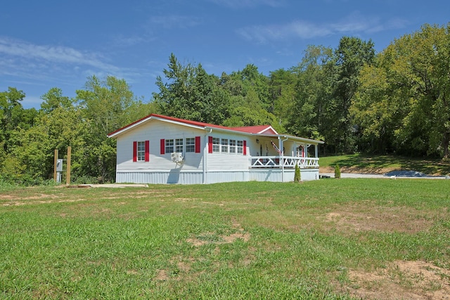 manufactured / mobile home featuring a front lawn and covered porch