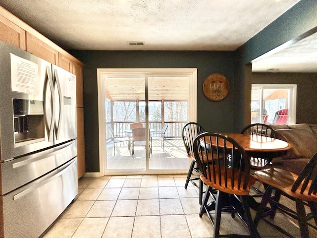 dining space with light tile patterned floors and a textured ceiling