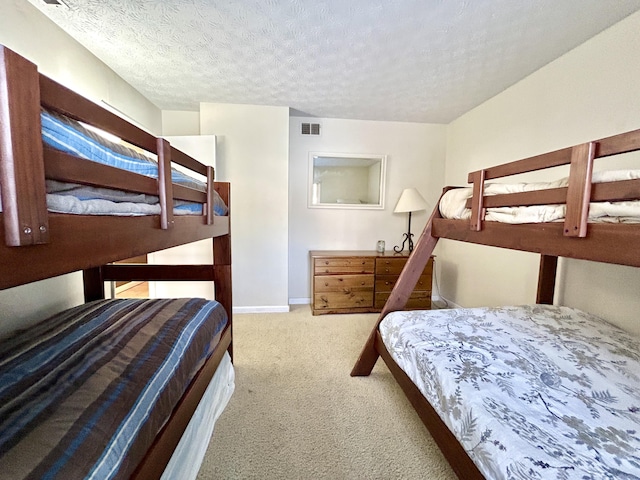 bedroom featuring light carpet and a textured ceiling