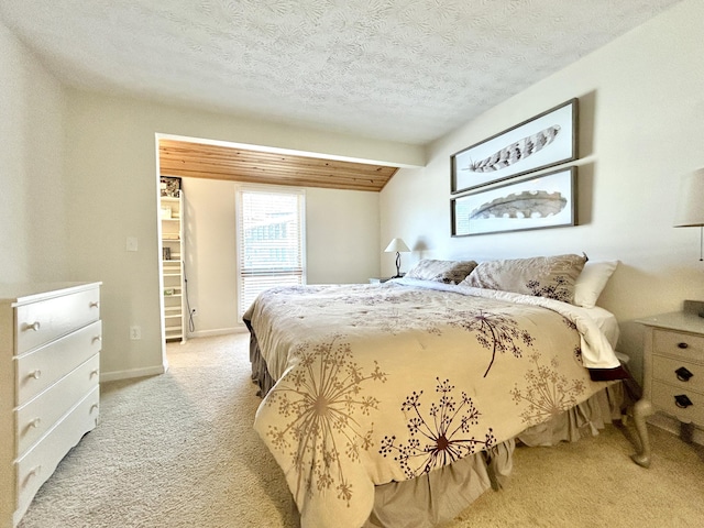 carpeted bedroom featuring a textured ceiling and vaulted ceiling with beams