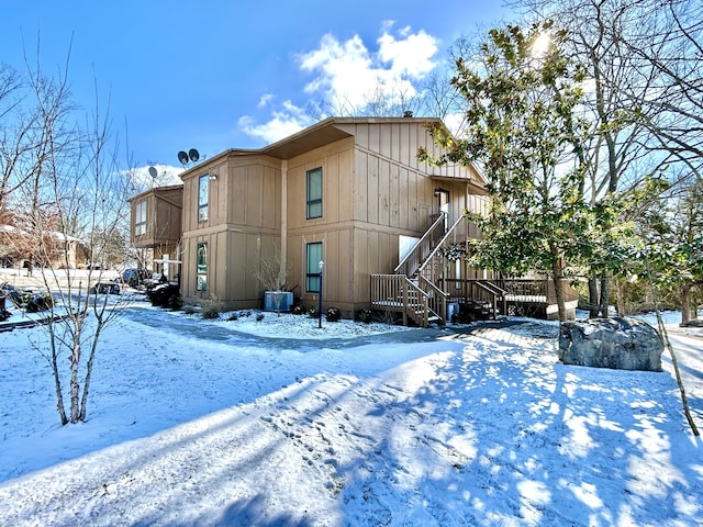 snow covered property featuring central AC unit