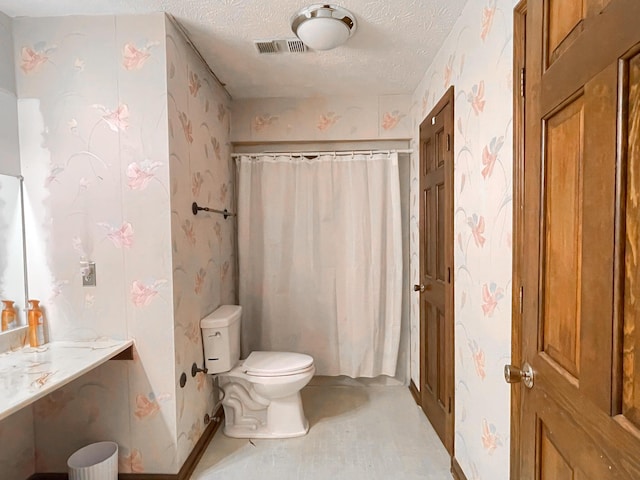 bathroom featuring toilet, walk in shower, and a textured ceiling