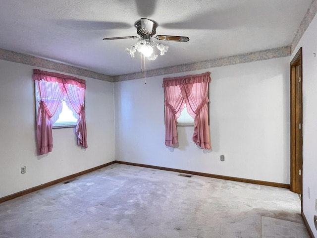 carpeted empty room with ceiling fan and a textured ceiling