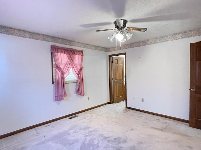 carpeted spare room featuring ceiling fan