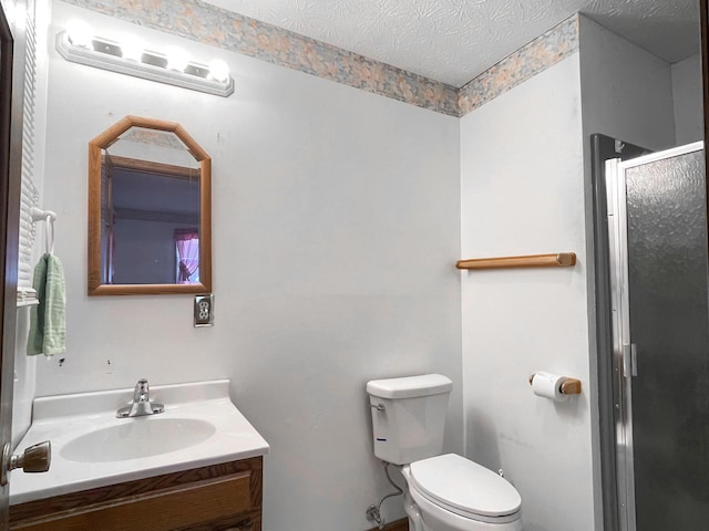 bathroom with a textured ceiling, toilet, walk in shower, and vanity