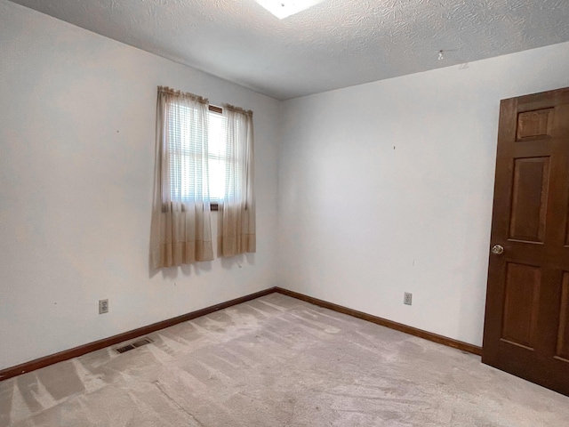 carpeted spare room with a textured ceiling