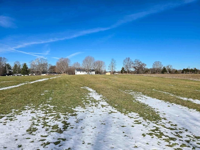 snowy yard featuring a rural view