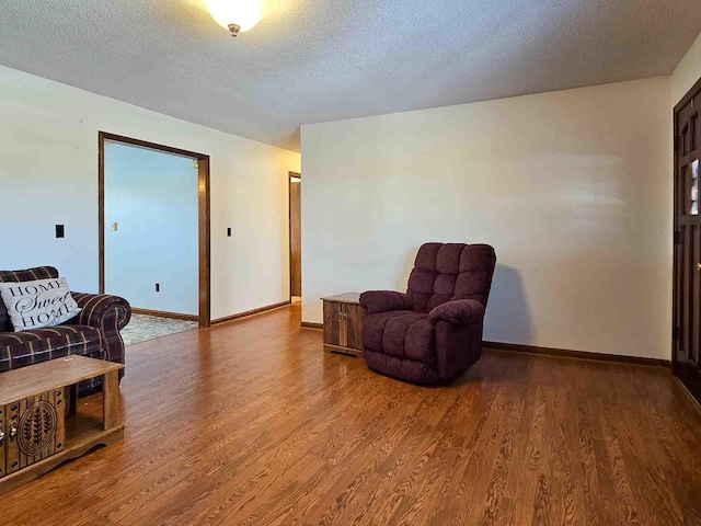 living area featuring hardwood / wood-style flooring and a textured ceiling