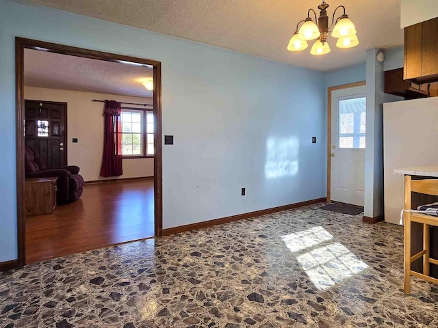 interior space with a notable chandelier and a textured ceiling