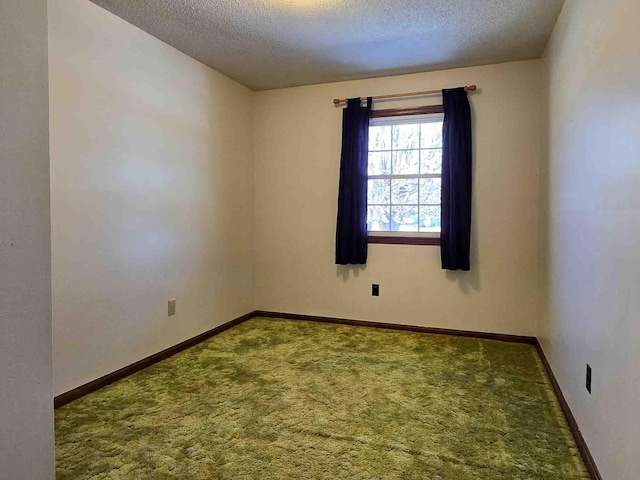 unfurnished room featuring carpet and a textured ceiling