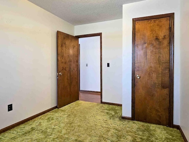 unfurnished bedroom featuring a textured ceiling and carpet flooring