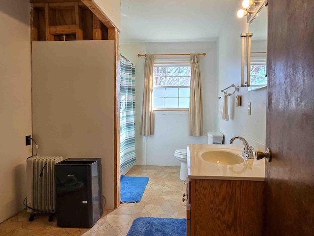 bathroom featuring tile patterned flooring, toilet, radiator heating unit, and vanity