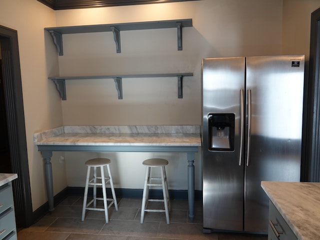 kitchen with dark tile patterned flooring and stainless steel fridge with ice dispenser