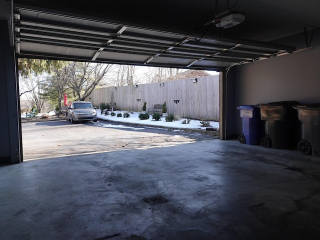 snow covered garage featuring a garage door opener