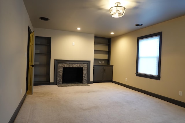 unfurnished living room with light carpet and a high end fireplace