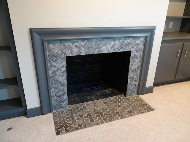 room details featuring a tile fireplace and carpet floors