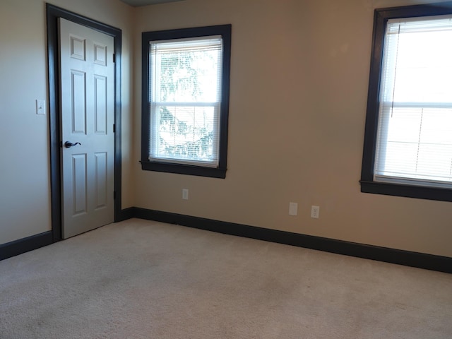 spare room with a healthy amount of sunlight and light carpet