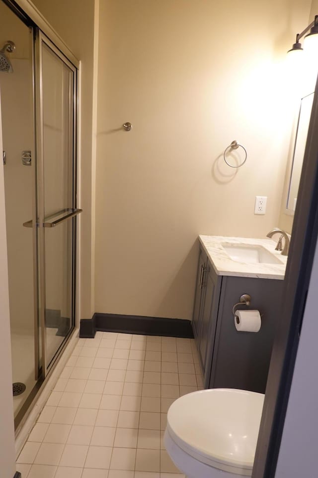 bathroom featuring an enclosed shower, vanity, tile patterned floors, and toilet