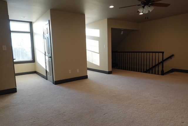 carpeted spare room featuring ceiling fan