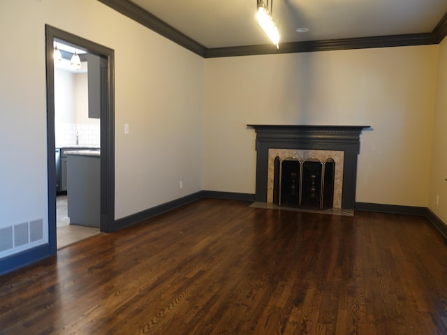 unfurnished living room with dark wood-type flooring, ornamental molding, and a premium fireplace