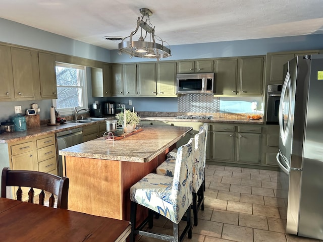 kitchen with a kitchen island, pendant lighting, sink, decorative backsplash, and stainless steel appliances