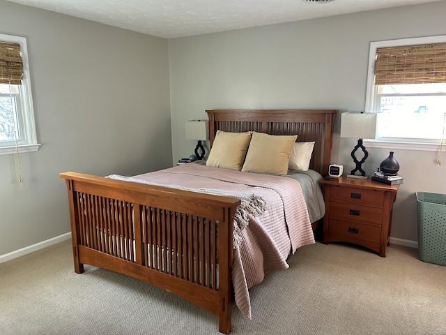 bedroom featuring light colored carpet and a textured ceiling