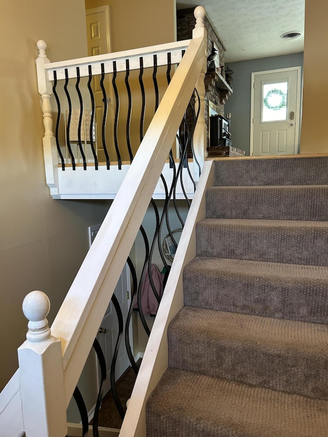 staircase with a textured ceiling